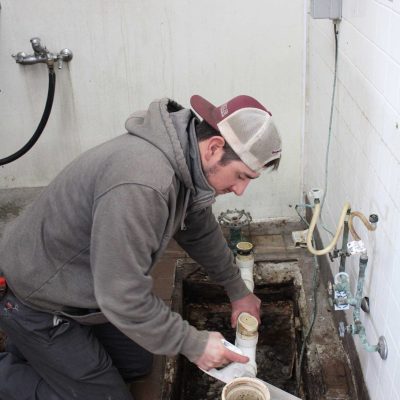 Ziegler plumbing associate cleaning a grease trap